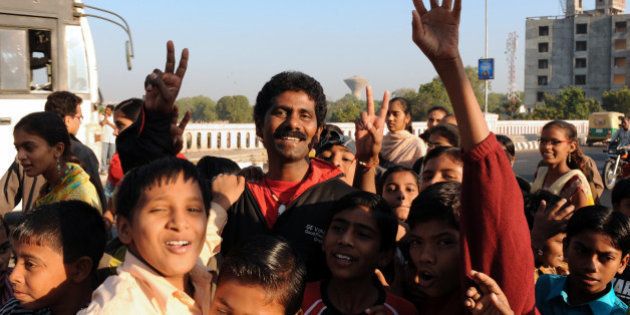 Indian mountaineer Malli Mastan Babu (C) poses with children in Ahmedabad on November 29, 2009, following a morale run with some 125 underpriviledged children and women. The 34-year old is the only South Asian to have scaled the seven highest mountain peaks in a record 172 days in 2006. AFP PHOTO/ Sam PANTHAKY (Photo credit should read SAM PANTHAKY/AFP/Getty Images)