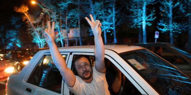 An Iranian man flashes the victory sign from his car while celebrating on a street in northern Tehran, Iran, Thursday, April 2, 2015, after Iran's nuclear agreement with world powers in Lausanne, Switzerland. Iran and six world powers reached a preliminary nuclear agreement Thursday outlining commitments by both sides as they work for a comprehensive deal aiming at curbing nuclear activities Tehran could use to make weapons and providing sanctions relief for Iran. (AP Photo/Vahid Salemi)