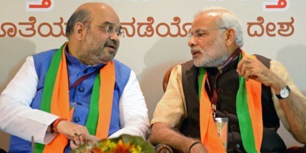 Indian Bharatiya Janata Party (BJP) national president Amit Shah (L) and Prime Minister Narendra Modi talk during a BJP office bearers' meeting held on the eve of the party's National Executive committee meeting in Bangalore on April 2, 2015. The two-day National Executive meeting, scheduled to begin on April 3, 2015 in Bangalore, will be the first such meeting since the BJP came to power last year. AFP PHOTO / Manjunath KIRAN (Photo credit should read MANJUNATH KIRAN/AFP/Getty Images)