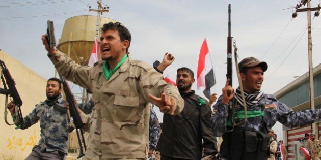 TIKRIT, IRAQ - APRIL 1: Iraqi forces, including soldiers, police officers, Shiite militias (al-Hashid al-Shaabi) and Sunni tribes, celebrate on April 1, 2015 after regained full control of Saddam Hussein's hometown of Tikrit, Iraq from Daesh on Wednesday. Daesh seized Tikrit last summer during its advance across northern and western Iraq. (Photo by Haydar Hadi/Anadolu Agency/Getty Images)