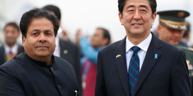 Japanese Prime Minister Shinzo Abe shakes hand with Indian Junior Minister for Parliamentary Affairs Rajeev Shukla upon arrival in New Delhi, India, Saturday, Jan. 25, 2014. Abe arrived Saturday on a three-day official visit to India and will also be the Chief Guest on Indiaâs Republic Day parade, celebrated on Jan. 26. (AP Photo/Saurabh Das)