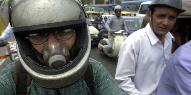 NEW DELHI, INDIA: A Delhi motorcyclist wears an air-filter while waiting for the light to change at a downtown crossing, 05 June 2000 in New Delhi. India was rated the worst country in Asia for air, water and noise pollution by a private think-tank. The world celebrates Environment Day 05 June. (ELECTRONIC IMAGE) AFP PHOTO JOHN MACDOUGALL (Photo credit should read JOHN MACDOUGALL/AFP/Getty Images)