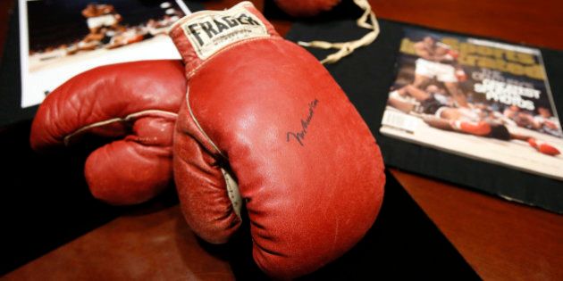 The boxing gloves of Muhammad Ali, front, and of Sonny Liston, rear, sit on a table at Heritage Auctions by a photo and magazine depicting a moment captured during the fight, Thursday, Jan. 22, 2015, in Dallas. The 1965 rematch between Ali and Liston remains one of the most controversial sporting events of the 20th century. To this day, 50 years later, questions swirl. Was it a knockout or âphantom punchâ that Ali threw when he decked Liston minutes into the first round of their heavyweight title fight. (AP Photo/Tony Gutierrez)