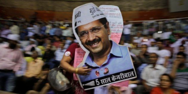 A supporter carries cut-outs of Delhi Chief Minister Arvind Kejriwal during a ceremony to launch an anti-corruption helpline in New Delhi, India, Sunday, April 5, 2015. (AP Photo/Altaf Qadri)