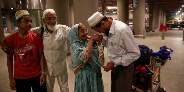 An Indian Muslim man greets his mother after she arrived at Chhatrapati Shivaji International Airport...