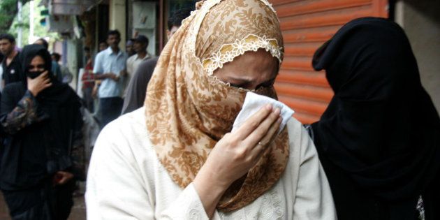 Raheen Memon, center, wife of Yakub Memon, reacts as she arrives at a special court trying cases of the 1993 Mumbai bombings that killed 257 people in Mumbai, India, Friday, July 27, 2007. Justice Pramod Kode handed down the death penalty to brother of Tiger Memon, Yakub and said he was one of the key persons who arranged for weapons and arms training and for storing explosives used in the March 12, 1993 blasts. (AP Photo/Rajesh Nirgude)