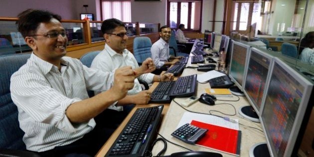 Indian stockbrokers celebrate as they watch the Bombay Stock Exchange (BSE) index on their trading terminal in Mumbai, India, Tuesday, May 13, 2014. India's stock market and currency rallied Tuesday on exit polls predicting election victory for a pro-business party and its allies. The Sensex stock index rose above 24,000 for the first time, gaining more than 2 percent before paring its gain. The dollar, meanwhile, fell to 59.60 rupees from 60.05 rupees on Monday. (AP Photo/Rajanish Kakade)