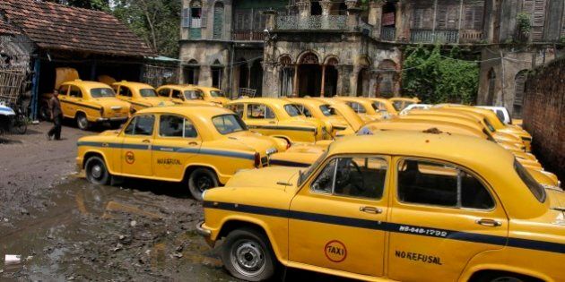 Ambassador cars, converted to yellow cabs are parked in front of a century old building during a daylong taxi strike in Kolkata, India, Wednesday, Sept. 10, 2014. The strike was called by the left party unions demanding fare hike and to protest alleged police atrocities. (AP Photo/ Bikas Das)