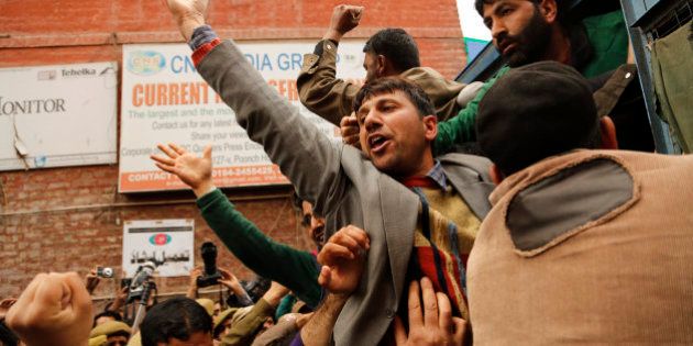 In this Wednesday, April 8, 2015 photo, Kashmiri government teacher shout slogans after being detained during a protest in Srinagar, Indian controlled Kashmir. Police detained dozens of government teachers during a protest alleging they have not been paid salaries for several months. (AP Photo/Mukhtar Khan)