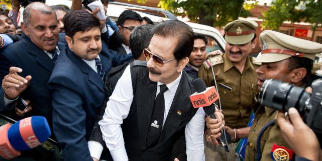 Security officials escort India's Sahara group chairman Subrata Roy (C) on his arrival at the Supreme Court in New Delhi on March 4, 2014. Black ink was thrown on Sahara chairman Subrata Roy's face as he arrived at the Supreme Court , escorted by police personnel. The attacker, who managed to get close to Roy in the crowd and threw black ink on him, claimed to be Manoj Sharma, a lawyer from Gwalior, Madhya Pradesh. Roy was arrested after he failed to respond to the Supreme Court's summons to appear in court in connection with the case in which Sahara owes millions of investors over 22,000 crore Indian rupees (3.5 billion dollars). AFP PHOTO/Prakash SINGH (Photo credit should read PRAKASH SINGH/AFP/Getty Images)