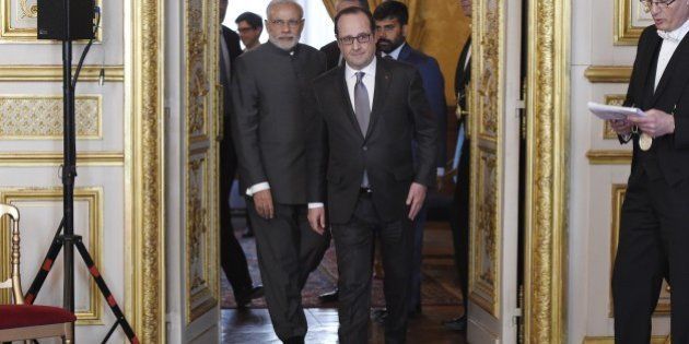 French President Francois Hollande (C) and Indian Prime Minister Narendra (L) Modi arrive for the Indo-French Economic Forum at the Elysee palace on April 10, 2015, in Paris. India's prime minister on April 10 kicked off talks in Paris with the French president with all eyes on a potential multi-billion-euro fighter jet deal hailed as the 'contract of the century.' AFP PHOTO / POOL / ALAIN JOCARD (Photo credit should read ALAIN JOCARD/AFP/Getty Images)