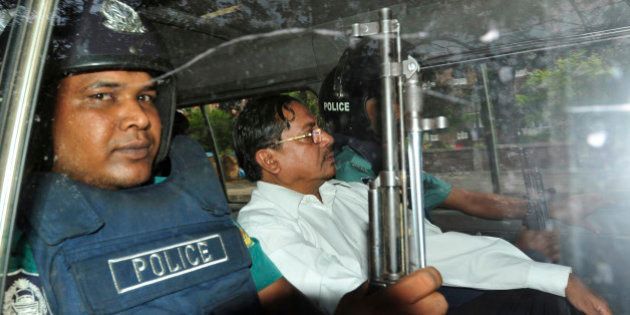Muhammad Kamaruzzaman, assistant secretary-general of the hardline Islamic party Jamaat-e-Islami, leaves a court escorted by policemen in Dhaka, Bangladesh, Thursday, May 9, 2013. A Bangladesh tribunal convicted the top Islamic party politician Thursday of atrocities stemming from the nation's 1971 independence war and sentenced him to death, triggering fears of another wave of deadly street violence between party supporters and security forces. (AP Photo/Khurshed Rinku)