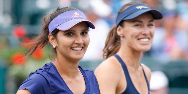 Sania Mirza, left, of India, celebrates with her teammate, Martina Hingis, of Switzerland, after defeating Alla Kudryavtseva and Anastasia Pavlyuchenkova during a doubles final match at the Family Circle Cup tennis tournament Sunday, April 12, 2015, in Charleston, S.C. Mirza and Hingis won 6-0, 6-4. (AP Photo/Mic Smith)
