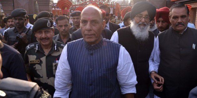 Union Home Minister Rajnath Singh (C), Punjab state chief minister Parkash Singh Badal (2R) and Border Security Force (BSF) Director General DK Pathak (L) walk during the closing ceremony for the Camel Safari expedition in Amritsar on March 22, 2015. In a joint venture by the BSF and Tata Steel Adventure Foundation (TSAF), 20 women are participating in the expedition which is a part of the BSF's Golden Jubilee celebrations. The expedition started from Bhuj in the state of Gujarat and will culminate at India-Pakistan Wagah border post on March 22, after travelling some 2300 kms. AFP PHOTO / NARINDER NANU (Photo credit should read NARINDER NANU/AFP/Getty Images)