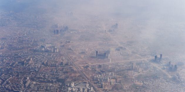 Smog envelops buildings on the outskirts of the Indian capital New Delhi on November 25, 2014. AFP PHOTO/Roberto SCHMIDT (Photo credit should read ROBERTO SCHMIDT/AFP/Getty Images)