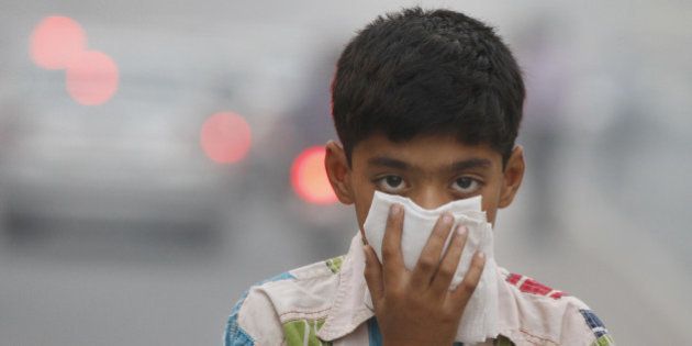 NEW DELHI, INDIA - NOVEMBER 07: A child covers its face to take precaution from the air pollution by a mixture of pollution and fog at NCR region on November 7, 2012 in New Delhi, India. (Photo by Sanjeev Verma/Hindustan Times via Getty Images)