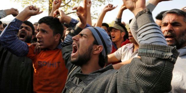 Kashmiri Muslim villagers shout slogans against Indian army during the funeral procession of Khaled Muzaffar, a civilian in Tral, some 38 Kilometers (24 miles) south of Srinagar, Indian controlled Kashmir, Tuesday, April 14, 2015. Violent protests erupted in the Indian-controlled portion of Kashmir on Tuesday after a civilian and a militant were killed in an encounter with the army, officials in the troubled Himalayan region said. Relatives and angry locals say the civilian was actually tortured to death.(AP Photo/Mukhtar Khan)