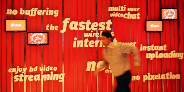 An employee of Bharti Airtel Limited runs after adjusting the screens of a promotional billboard during the launch of Airtel's 4G services in Kolkata on April 10, 2012. This is the first 4G service launched in the country and within a span of a month Airtel will launch its 4G service to the next three circles in the country which include Bangalore, Pune and Chandigarh. The company claims that the 4G services will deliver High Definition (HD) video streaming, instant photo and video downloads and high speed on wireless broadband. AFP PHOTO/Dibyangshu SARKAR (Photo credit should read DIBYANGSHU SARKAR/AFP/Getty Images)