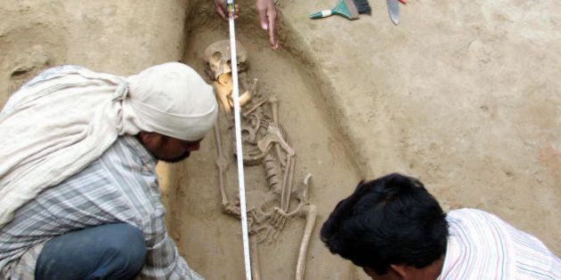 Research workers of India's Vishwa Bharati University measure a human skeleton found at an excavation site in Babupur village, Malda, some 350 Kms. north of Kolkata on February 23, 2008. The researchers working over four years, have allready recovered nine human skeleton form the historical ruins which is expected to be from the Paul and Sen era of 7th century. AFP PHOTO/STR (Photo credit should read STR/AFP/Getty Images)