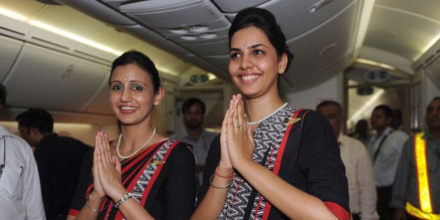 Air India flight attendants pose for a photo during the unveiling of Air India's first Boeing 787 Dreamliner at Indira Gandhi International airport terminal 3 in New Delhi, on September 12, 2012. The factory fresh 256-seater Boeing 787 Dreamliner is the first of 27 Dreamliners Air India has purchased for their fleet. AFP PHOTO/ RAVEENDRAN (Photo credit should read RAVEENDRAN/AFP/GettyImages)