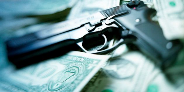 pistol lying on dollar notes