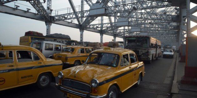 Indian commuters and taxi drivers navigate through heavy traffic on Howrah Bridge in Kolkata on November 7, 2014, where Bollywood actor Amitabh Bachchan is shooting scenes for the film 'Piku'. Bachchan is shooting scenes in the eastern Indian city for the forthcoming film 'Piku' directed by Sujit Sarkar, with Deepika Padukone and Irrfan Khan also taking part. AFP PHOTO/Dibyangshu SARKAR (Photo credit should read DIBYANGSHU SARKAR/AFP/Getty Images)