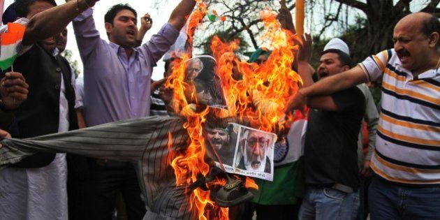 India's Hindu right-wing activists prepare to burn an effigy of an effigy with pictures of Jammu and Kashmir Chief Minister Mufti Mohammed Sayeed. Kashmiri separatist leader Syed Ali Shah Geelani and Masarat Alam during a protest in Jammu, India, Thursday, April 16, 2015. The right-wing activists were protesting after Kashmiri supporters raised pro-Pakistan slogans and waved Pakistani flags at a rally organized by separatists in Indian controlled Kashmir Wednesday. (AP Photo/Channi Anand)