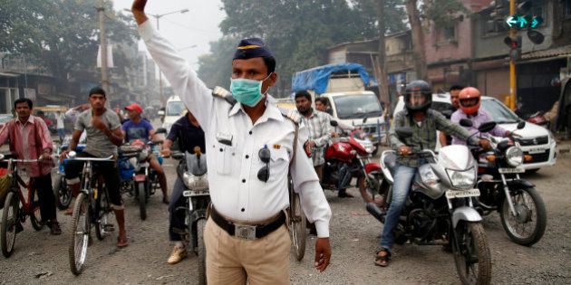 A traffic policeman wears a mask and controls traffic on a busy road in Mumbai, India, Tuesday, April 14, 2015. Air pollution kills millions of people every year, including more than 627,000 in India, according to the World Health Organization. The WHO puts 13 Indian cities in the world's 20 most polluted. (AP Photo/Rajanish Kakade)