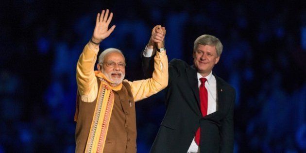 Canadian Prime Minister Stephen Harper (R) and Indian Prime Minister Narendra Modi (L) acknowledge the crowd during a rally on Prime Minister Modi's first official visit to Canada, April 15, 2015 in Toronto. AFP PHOTO / GEOFF ROBINS (Photo credit should read GEOFF ROBINS/AFP/Getty Images)