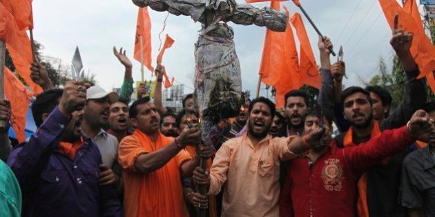 India's Hindu right-wing Shiv Sena activists prepare to burn an effigy of Kashmiri separatist Masarat Alam during a protest in Jammu, India, Thursday, April 16, 2015. The right-wing activists were protesting after Kashmiri supporters raised pro-Pakistan slogans and waved Pakistani flags at a rally organized by separatists in Indian controlled Kashmir Wednesday. (AP Photo/Channi Anand)