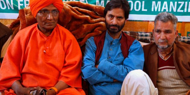 Chairman of the Jammu Kashmir Liberation Front (JKLF) Yasin Malik, center, sits for a 30-hour- long hunger strike, with social activist Swami Agnivesh, left, sitting in support in Srinagar, Indian controlled Kashmir, Saturday, April 18, 2015. Malik along with his supporters began a 30-hour hunger strike to protest Indiaâs plan to build townships for Hindus who fled a rebellion in Muslim-majority areas. (AP Photo/Mukhtar Khan)