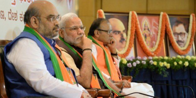 Indian Bharatiya Janata Party (BJP) national president Amit Shah (L), Prime Minister Narendra Modi (C) and Finance Minister Arun Jaitely look on during a BJP office bearers' meeting held on the eve of the party's National Executive committee meeting in Bangalore on April 2, 2015. The two-day National Executive meeting, scheduled to begin on April 3, 2015 in Bangalore, will be the first such meeting since the BJP came to power last year. AFP PHOTO / Manjunath KIRAN (Photo credit should read MANJUNATH KIRAN/AFP/Getty Images)