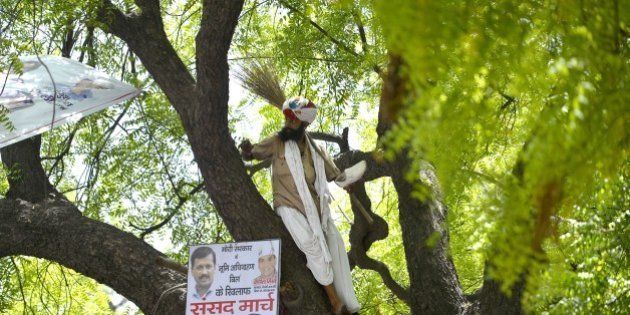 Indian farmer Gajendra Singh stands on a tree before committing suicide during an Aam Aadmi Party rally in New Delhi on April 22, 2015. A farmer hanged himself in front of hundreds of protesters gathered in the centre of the Indian capital on April 22 to rally against the government's contentious reform of land purchasing laws. AFP PHOTO/Chandan KHANNA (Photo credit should read Chandan Khanna/AFP/Getty Images)