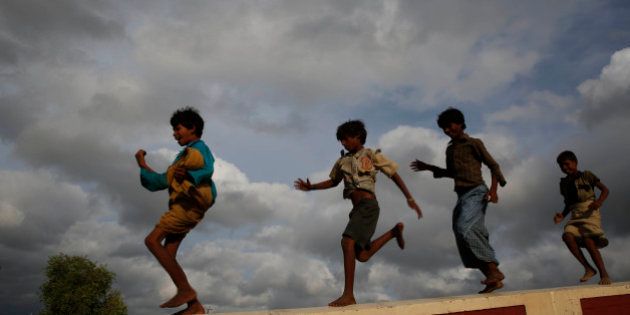 Children play as monsoon clouds hover in the sky, in Allahabad, India, Sunday, July 6, 2014. The monsoon rains which usually hit India from June to September are crucial for farmers whose crops feed hundreds of millions of people.(AP Photo/ Rajesh Kumar Singh)