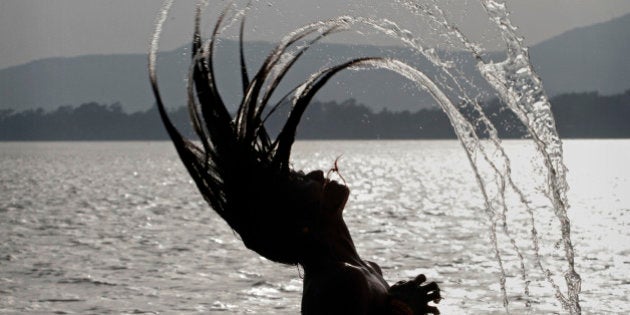 An Indian woman throws her wet hair back as she bathes in the River Brahmaputra in Gauhati, India, Monday, June 7, 2010. (AP Photo/ Anupam Nath)