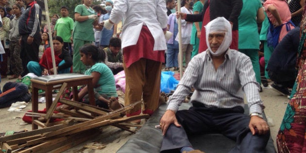 Injured people receive treatment outside the Medicare Hospital in Kathmandu, Nepal, Saturday, April 25, 2015. A strong magnitude-7.9 earthquake shook Nepal's capital and the densely populated Kathmandu Valley before noon Saturday, causing extensive damage with toppled walls and collapsed buildings, officials said. (AP Photo/ Niranjan Shrestha)