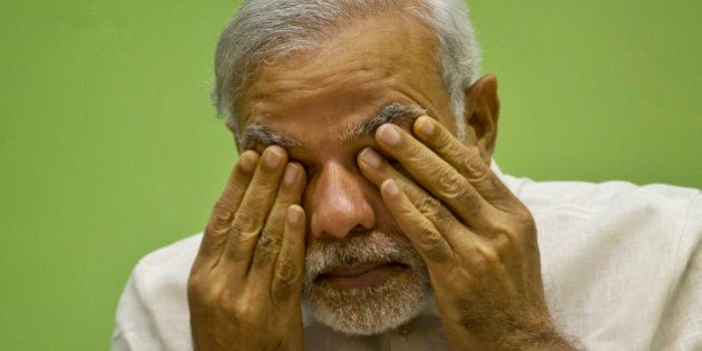 Indiaâs Prime Minister Narendra Modi rubs his eye as he attends a conference by The Environment Ministry in New Delhi, India, Monday, April 6, 2015. Modi launched Monday National Air Quality Index for 10 cities in India during the national conference. Experts say India's index falls short of international standards by using a formula that downplays how dangerous the air quality is on any given day. (AP Photo/Saurabh Das)
