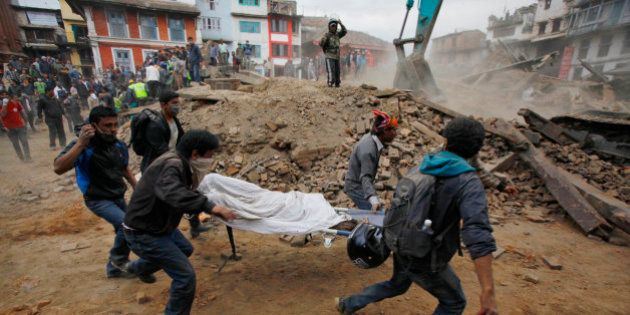 Volunteers carry the body of a victim on a stretcher, recovered from the debris of a building that collapsed after an earthquake in Kathmandu, Nepal, Saturday, April 25, 2015. A strong magnitude-7.9 earthquake shook Nepal's capital and the densely populated Kathmandu Valley before noon Saturday, causing extensive damage with toppled walls and collapsed buildings, officials said. (AP Photo/ Niranjan Shrestha)