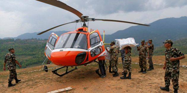 Nepalese soldiers load a helicopter with emergency supplies at a landing zone in the town of Gorkha, Nepal, Tuesday, April 28, 2015. Helicopters crisscrossed the skies above the high mountains of Gorkha district on Tuesday near the epicenter of the weekend earthquake, ferrying the injured to clinics, and taking emergency supplies back to remote villages devastated by the disaster. (AP Photo/Wally Santana)