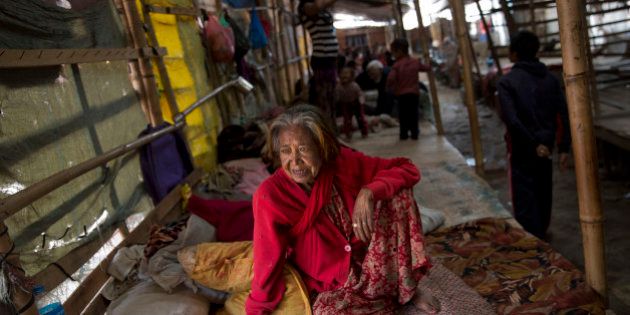 An elderly woman watches as she sits inside a residents makeshift area in Bhaktapur, Nepal, Tuesday, April 28, 2015. Many people have camped outdoors in the chilly night cold since Saturdayâs massive earthquake that shook Nepalâs capital and the densely populated Kathmandu valley. (AP Photo/Bernat Armangue)