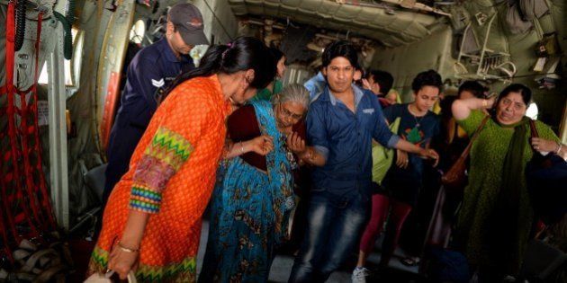 Indian Air Force (IAF) personnel assist an elderly Indian woman, as she disembarks from an IAF aircraft on arrival from Nepal, at Palam Air Force Station near New Delhi on April 28, 2015, after she and others were transported from the earthquake stricken Himalayan nation. Hungry and desperate villagers rushed towards relief helicopters in remote areas of Nepal, begging to be airlifted to safety, four days after a monster earthquake killed more than 5,000 people. AFP PHOTO/Chandan KHANNA (Photo credit should read Chandan Khanna/AFP/Getty Images)