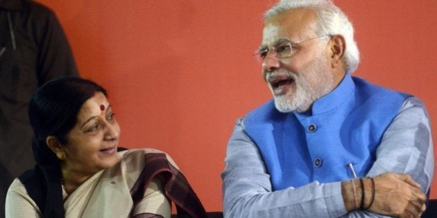 Indian Bharatiya Janata Party (BJP) leader and prime-minister elect Narendra Modi (R) talks with senior...