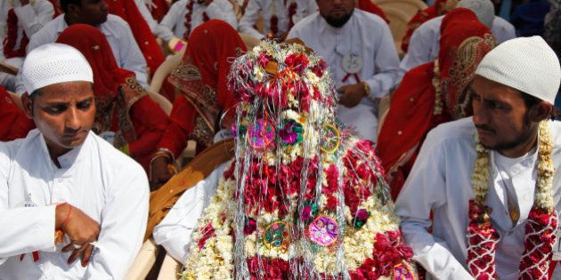 An Indian groom sits decorated with flowers during a mass marriage ceremony in Ahmadabad, India, Saturday, March 21, 2015. 112 Muslim couples from impoverished families tied the knot in a single ceremony organized by a social organization. (AP Photo/Ajit Solanki)
