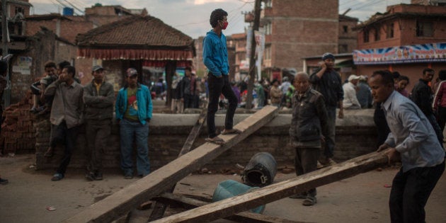 BHAKTAPUR, NEPAL - APRIL 29: Nepalese earthquake victims block a street as they protest against the lack of help from the Nepalese Government on April 29, 2015 in Bhaktapur, Nepal. A major 7.8 earthquake hit Kathmandu mid-day on Saturday, and was followed by multiple aftershocks that triggered avalanches on Mt. Everest that buried mountain climbers in their base camps. Many houses, buildings and temples in the capital were destroyed during the earthquake, leaving over 5000 dead and many more trapped under the debris, as emergency rescue workers attempt to clear debris and find survivors. Regular aftershocks have hampered recovery missions as locals, officials and aid workers attempt to recover bodies from the rubble. (Photo by David Ramos/Getty Images)