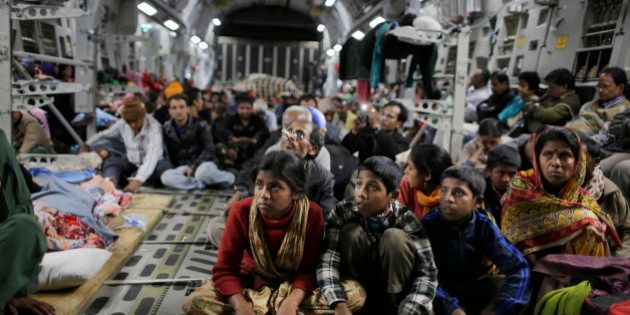 Survivors of Saturday's earthquake hold on to a cable as a military takes off with evacuees from Kathmandu to New Delhi during a midnight rescue mission by Indian Air Force, in Kathmandu, Nepal, Wednesday, April 29, 2015. (AP Photo/Altaf Qadri)