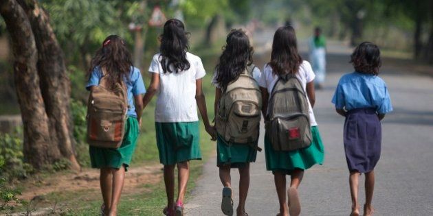 Indian girls walk to a school at Burha Mayong village about 45 kilometers (28 miles) east of Gauhati, India, Thursday, April 9, 2015. According to the UNESCO Education for All Global Monitoring Report 2015, only half of all countries have achieved the most watched goal of universal primary enrollment. The report launched Thursday says, India has reduced its out of school children by over 90% Since 2000. (AP Photo/ Anupam Nath)