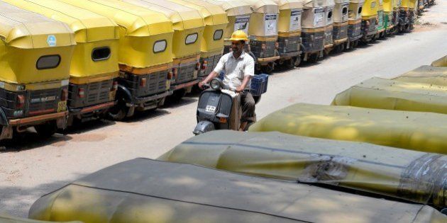 A man rides past parked auto rickshaws during a strike against a proposed new Road Transport and Safety Bill 2015 in Bangalore on April 30, 2015. AFP PHOTO/Manjunath KIRAN (Photo credit should read MANJUNATH KIRAN/AFP/Getty Images)