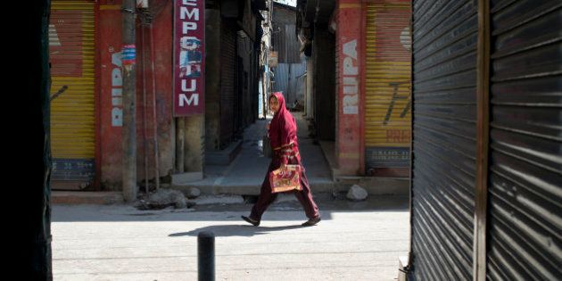 A Kashmiri Muslim woman walks past a closed market are during a strike in Srinagar, Indian controlled Kashmir, Saturday, April 11, 2015. Kashmiris closed shops and businesses in the disputed Himalayan region Saturday to protest Indiaâs plan to build townships for Hindus who fled a rebellion in Muslim-majority areas. Many of the Hindus, known as Pandits, had fled to Hindu-dominated areas in Jammu region or elsewhere in India in 1990. (AP Photo/Dar Yasin)
