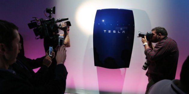 People look at newly-unveiled Tesla Powerwall batteries at the Tesla Design Studio in Hawthorne, California, April 30, 2015. Electric car pioneer Telsa Motors unveiled a 'home battery' Thursday which its founder Elon Musk said would help change the 'entire energy infrastructure of the world.' AFP PHOTO / David McNew (Photo credit should read DAVID MCNEW/AFP/Getty Images)