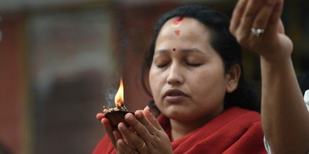A Nepalese woman offers prayers in Kathmandu on May 2, 2015. Nepal has ruled out the possibility of finding more survivors buried in the rubble from a massive earthquake that killed more than 6,700 people and devastated vast swathes of one of Asia's poorest countries. AFP PHOTO/PRAKASH SINGH (Photo credit should read PRAKASH SINGH/AFP/Getty Images)